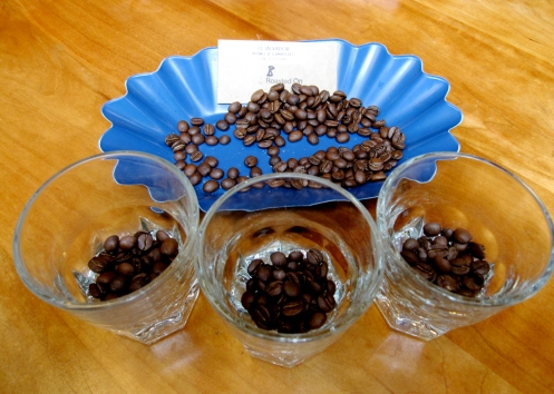 Three cups of unground coffee beans
